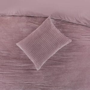 Roze geribbelde kussen en sprei op bed