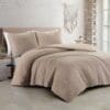 Comfortabel bed met beige dekbedovertrek en kussens.