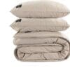Gestapelde beige kussens en dekbed set