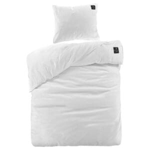 Wit dekbedovertrek en kussensloop set opgemaakt bed